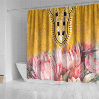 Yellow shower curtain featuring dashiki emblem and large pink protea flowers