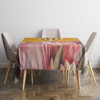 Floral tablecloth with pink and cream petals and yellow tones, draped over square table