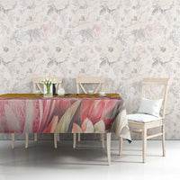 Floral tablecloth with pink and beige petals on a yellow background, draped over table