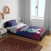 Blue and red Liberia crest bedding set on a bed, showing white dove and “YOUR TEXT” print.