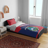 Red and navy Liberia bedding set on bed with crest emblem and two red pillowcases