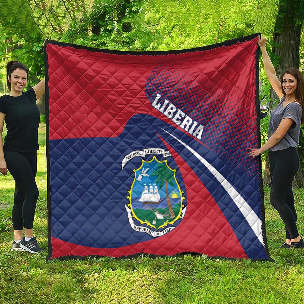 Liberia flag quilt spread on grass, red and blue diagonal stripes with central coat of arms