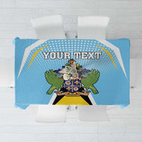 Blue tablecloth with centered crest and decorative border, "YOUR TEXT" banner.