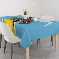 Blue tablecloth with crest print across the table surface with dining settings.