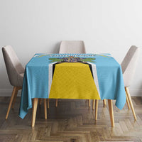 Blue tablecloth on dining table with crest graphic and yellow shield centerpiece.