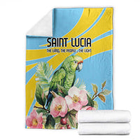 Blue blanket with parrot and pink blossoms, folded with two white towels