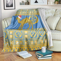 Blue camel and Santa hat blanket with gold patterned band, laid across a couch