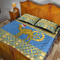 Blue quilt bed set with camel emblem and gold geometric border on bed, with two pillows