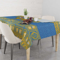 Blue tablecloth with yellow patterned emblem and geometric motifs along edges
