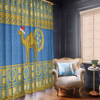 Blue window curtains with gold Eritrea emblem and camel figure with Santa hat