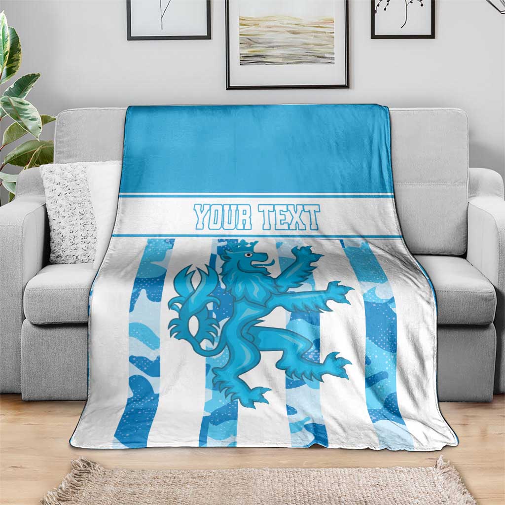 Personalized Luxembourg blanket on sofa, blue and white stripes with crest and “YOUR TEXT”