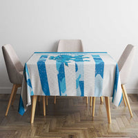 Blue patterned tablecloth on a square table with four upholstered chairs