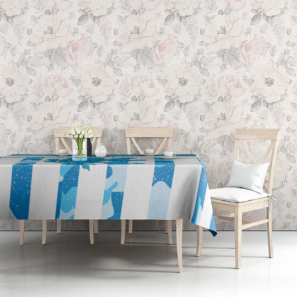 Blue grunge tablecloth on dining table with chairs, vase, and cups