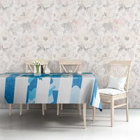 Blue grunge tablecloth on dining table with chairs, vase, and cups