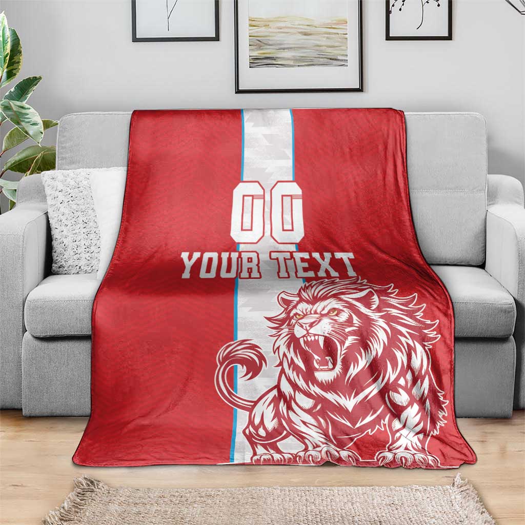 Red throw blanket on gray sofa; white stripe with YOUR TEXT and lion emblem