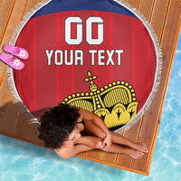 Red circular football beach blanket with blue top stripe, white fringe edge, yellow crest