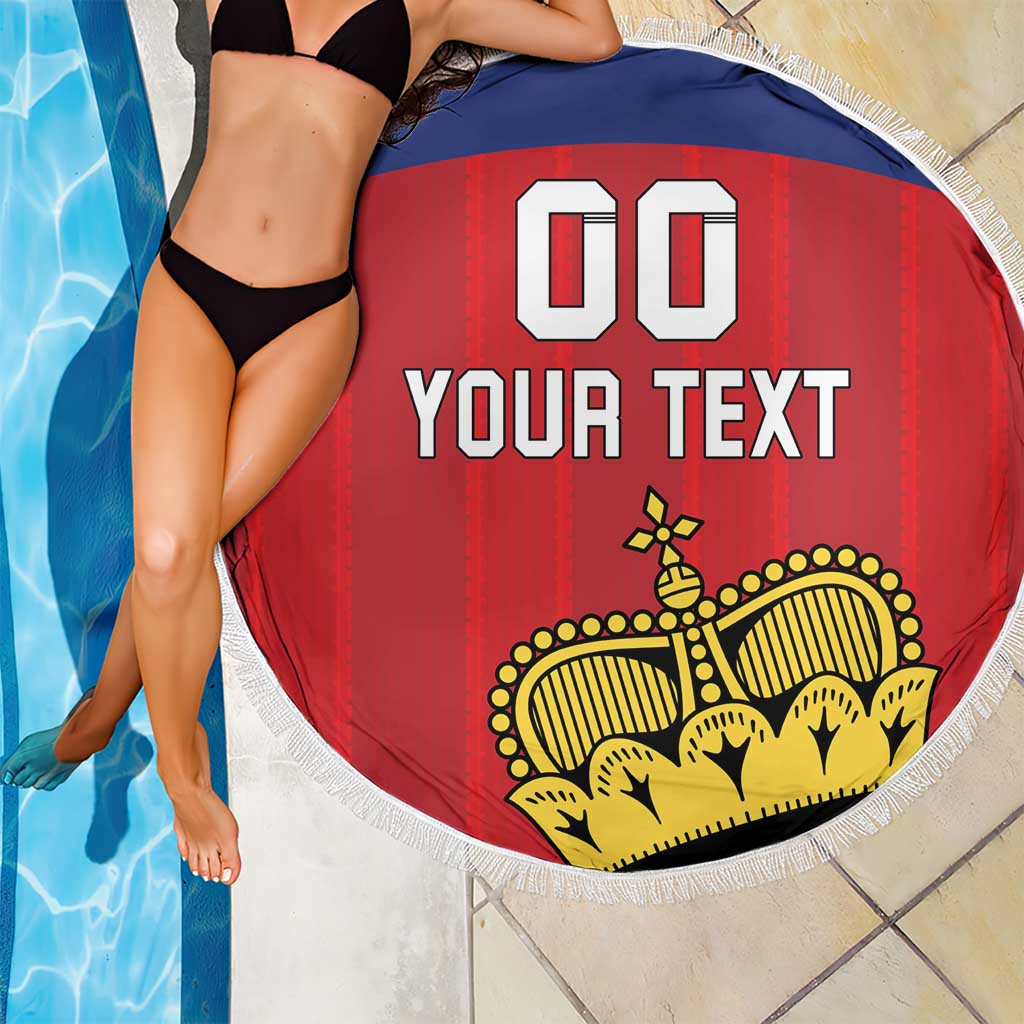 Red circular football beach blanket with yellow crest and white fringe edge by pool