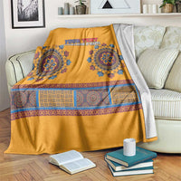 Yellow dashiki-style blanket with blue motifs, draped over gray reverse fabric