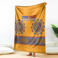 Yellow dashiki-style blanket draped upright with blue emblem band and 'YOUR TEXT' text