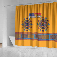 Yellow shower curtain featuring custom text and blue decorative emblems with patterned border