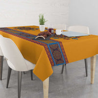 Yellow dashiki tablecloth with blue patterned border on dining table with matching items