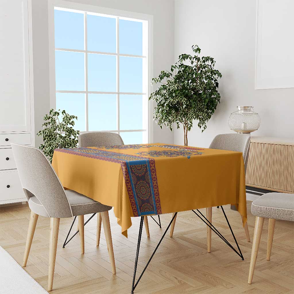Yellow dashiki tablecloth with blue decorative stripe on dining table and chairs