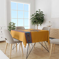 Yellow dashiki tablecloth with blue decorative stripe on dining table and chairs