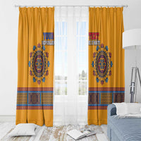 Yellow dashiki window curtains with top hooks, blue emblem, and colorful trim