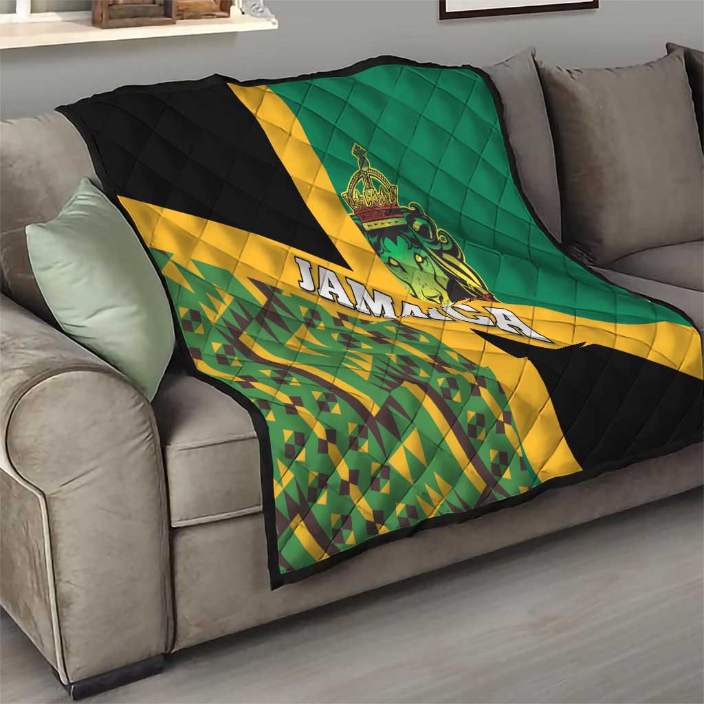 Green, yellow, and black kente-pattern quilt with Jamaica text and lion crest on sofa