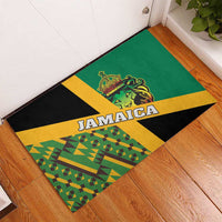 Green rubber doormat on floor with Jamaica text and lion crest in bold diagonal design.