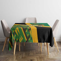 Green tablecloth with geometric Kente pattern, black panel, and lion crest at center