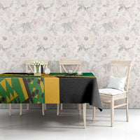 Green tablecloth with yellow and black geometric Kente pattern and lion emblem