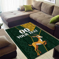Green area rug featuring springbok, yellow border accents and '00 YOUR TEXT' design