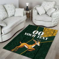 Green area rug with springbok graphic, '00 YOUR TEXT' lettering and yellow geometric border