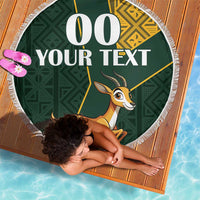 Round green beach blanket with fringe edge, springbok graphic and custom text panel