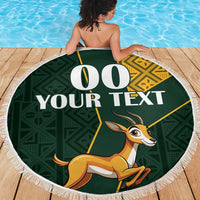Round green beach blanket with fringe edge, springbok graphic and bold custom text