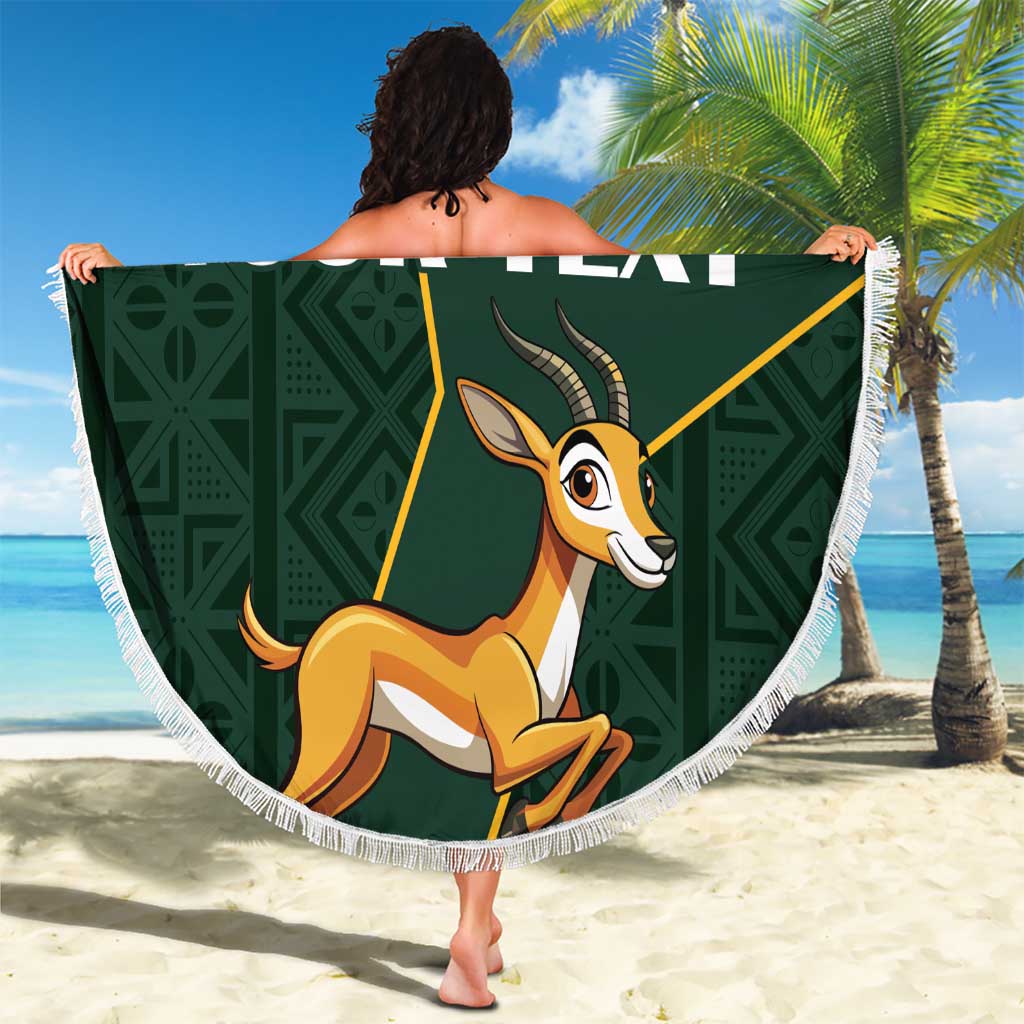 Round green beach blanket with fringe edge, springbok graphic on dark Kente pattern