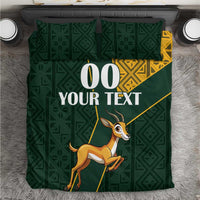 Green duvet and pillow bedding set with yellow Kente pattern trim and springbok graphic