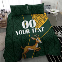 Green bedding set with Kente-style yellow accents and springbok graphic, custom text center