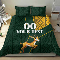Green duvet bedding set with yellow Kente trim and springbok illustration across the center