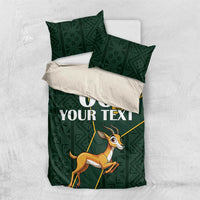 Green bedding set with matching pillows featuring yellow Kente accents and springbok graphic