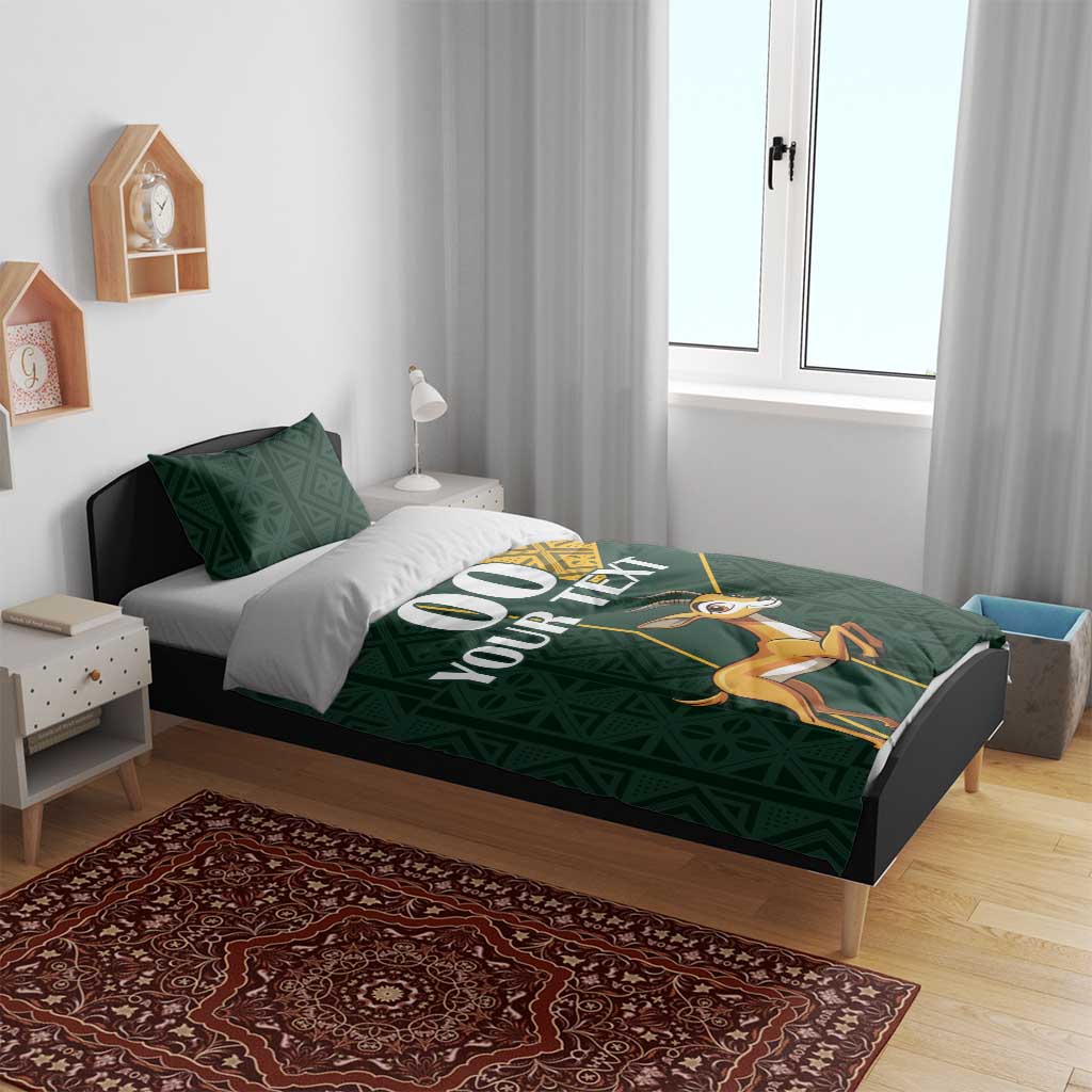 Green duvet bedding set with yellow Kente border and springbok design on bed