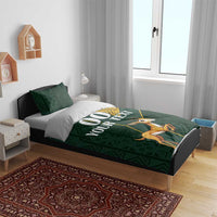 Green duvet bedding set with yellow Kente border and springbok design on bed