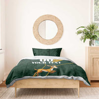 Green bedding set with yellow Kente-style panel and springbok graphic on duvet top