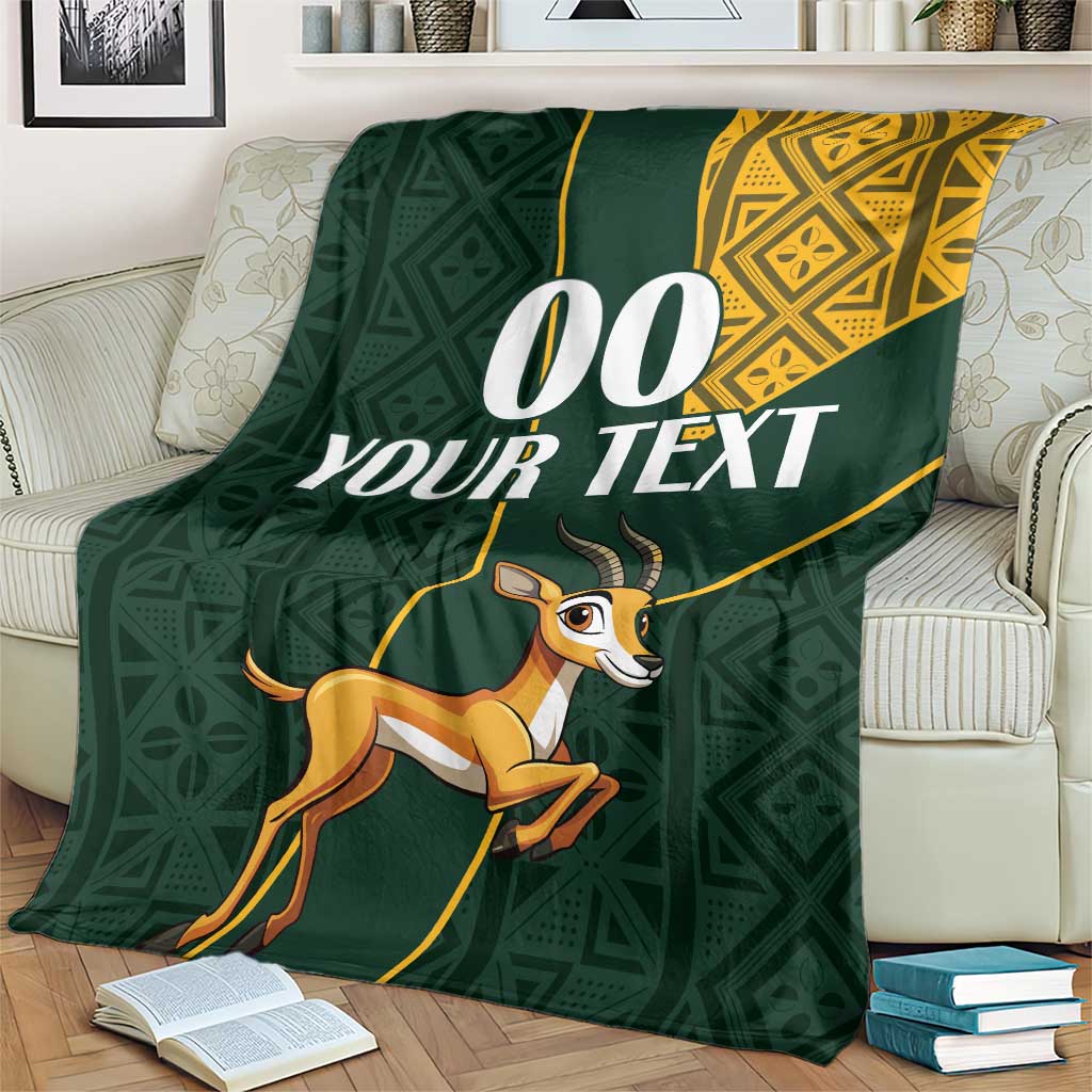 Green springbok jumping blanket draped on couch with yellow border and custom text