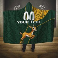 Hooded blanket with green geometric pattern, yellow trim, and customizable text panel
