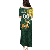 Long green dress, back view, custom text with Springbok print and yellow kente panel