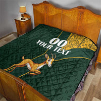 Dark green quilt on bed with yellow Kente-style edge, jumping springbok, “00 YOUR TEXT”