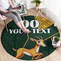 Round area rug, dark green with springbok and large “YOUR TEXT” print, yellow kente border
