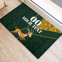 Green rubber doormat with custom 00 YOUR TEXT, springbok and dark geometric pattern
